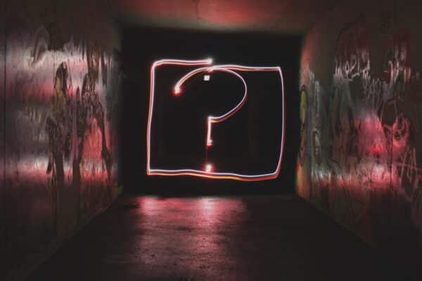 Question mark made out of lights in a dark street alley