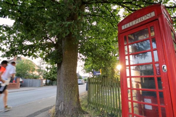 Red phone booth on a quiet street