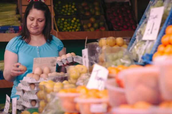 A woman in a blue top grocery shopping