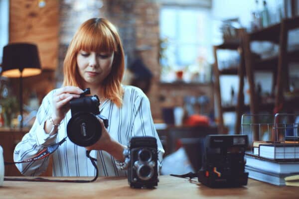 Woman with auburn hair holding a camera