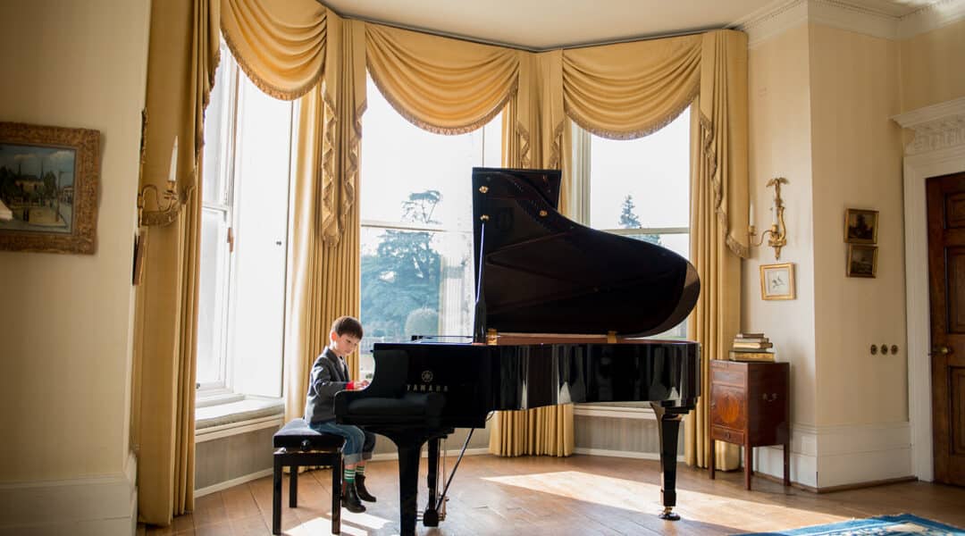 Young child playing the piano in the living room