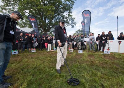 Man using a metal detector in a field