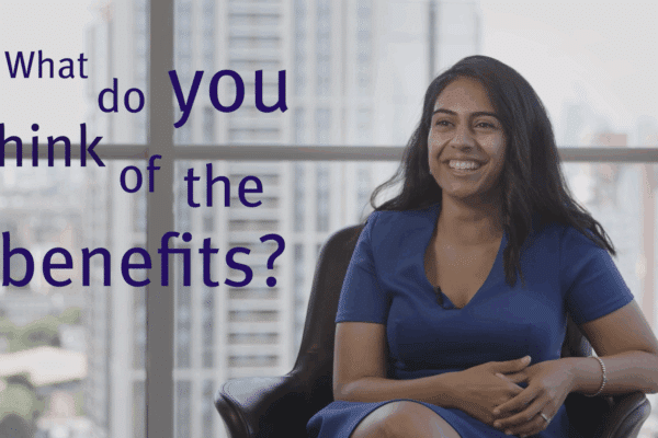 Woman smiling in a chair and on-screen text reading "What do you think of the benefits?'