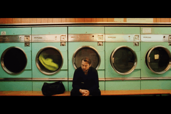 Man sat in Launderette looking sad