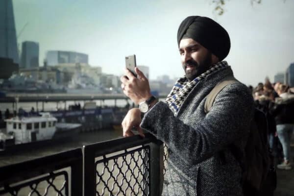 Man using phone overlooking thames with shard in background