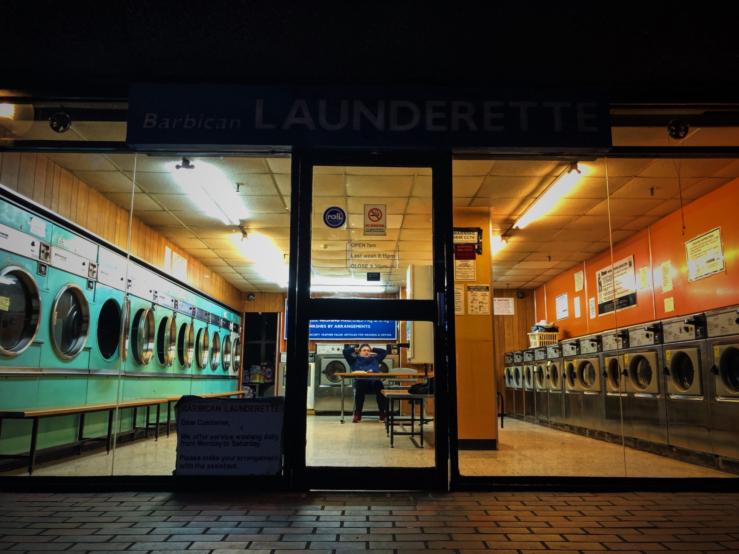 man sitting alone in a laundrette