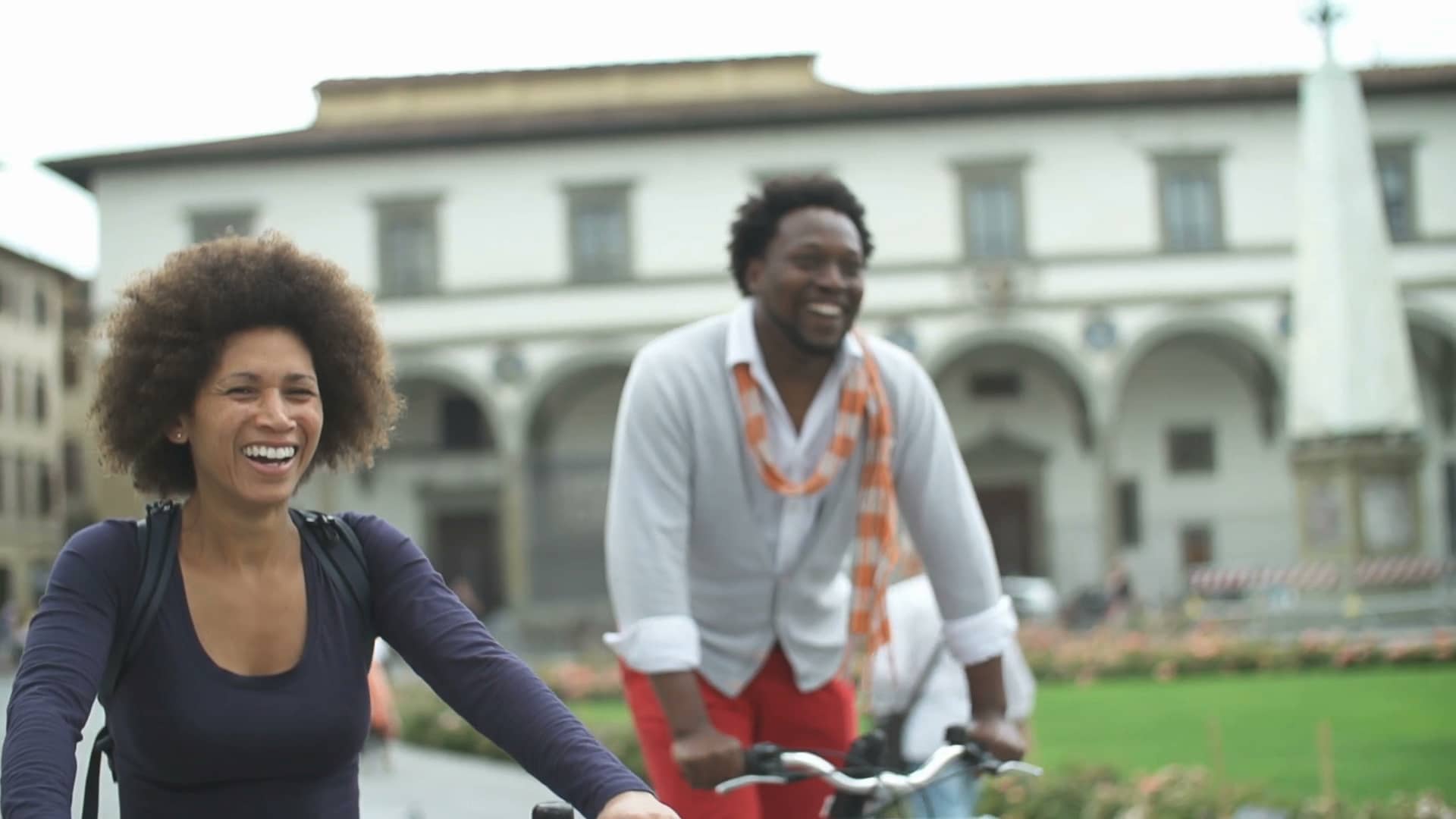 two people riding a bike in the city 