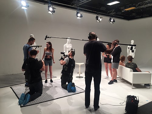 A boom operator in a studio recording sound