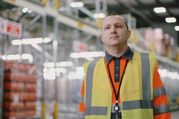 White man in a warehouse with high viz jacket