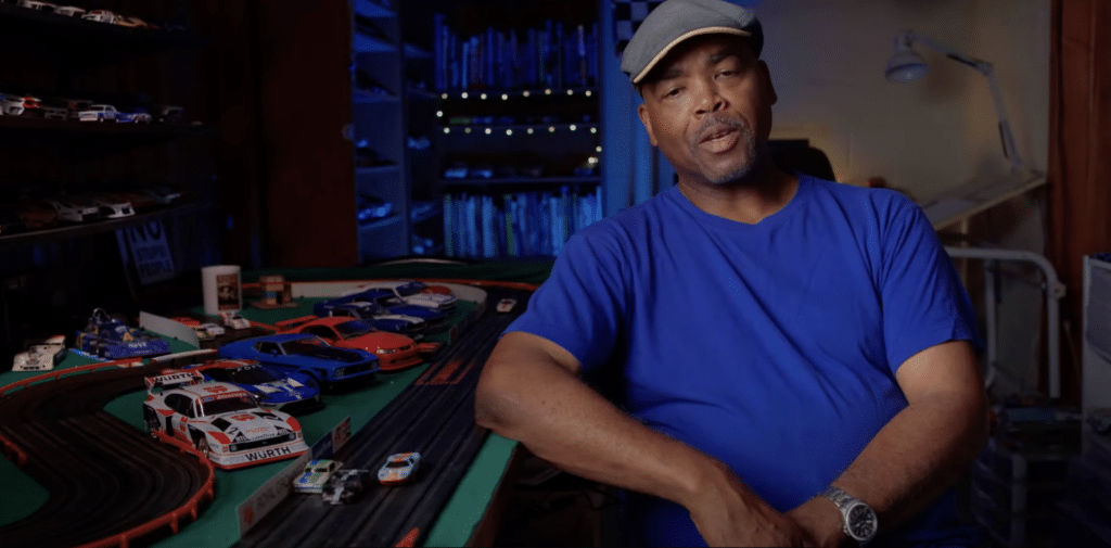 Interview showing worker with toy cars in the background