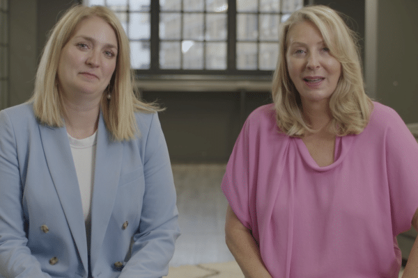 Two women talking to camera in a fireside chat interview setting